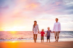 Family Standing on Beach During Sunset