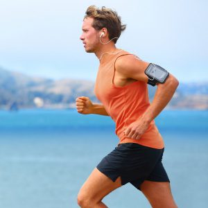 Young Male Running along Beach in Sportswear