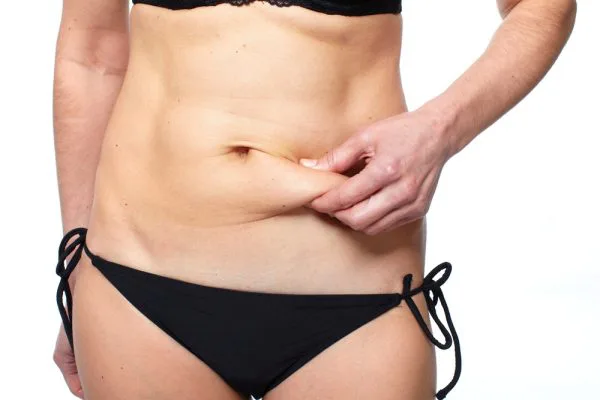 Female hand squeezing fat in tummy area