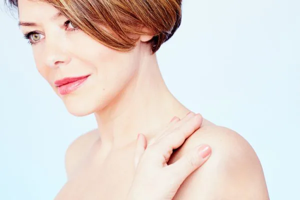 Mature female model with bare shoulders and short red hair