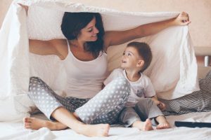 Mother and Young Boy Playing under Covers