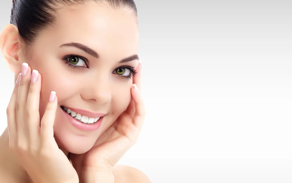 Model touching face with manicured hands