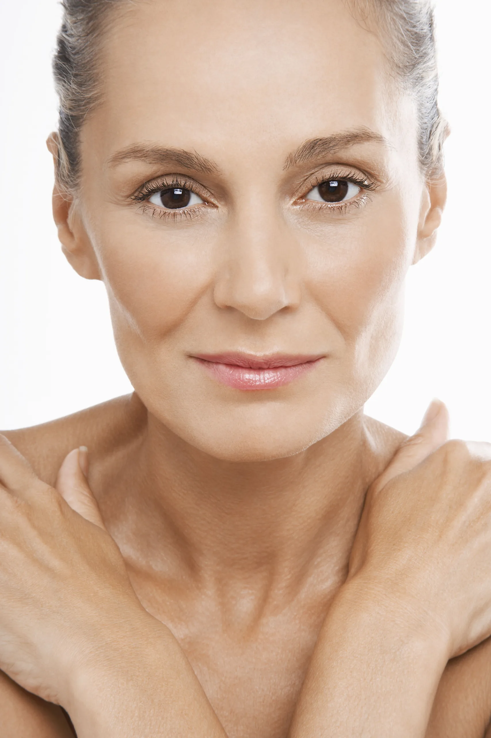 Older woman with hands crossed over bare chest copy