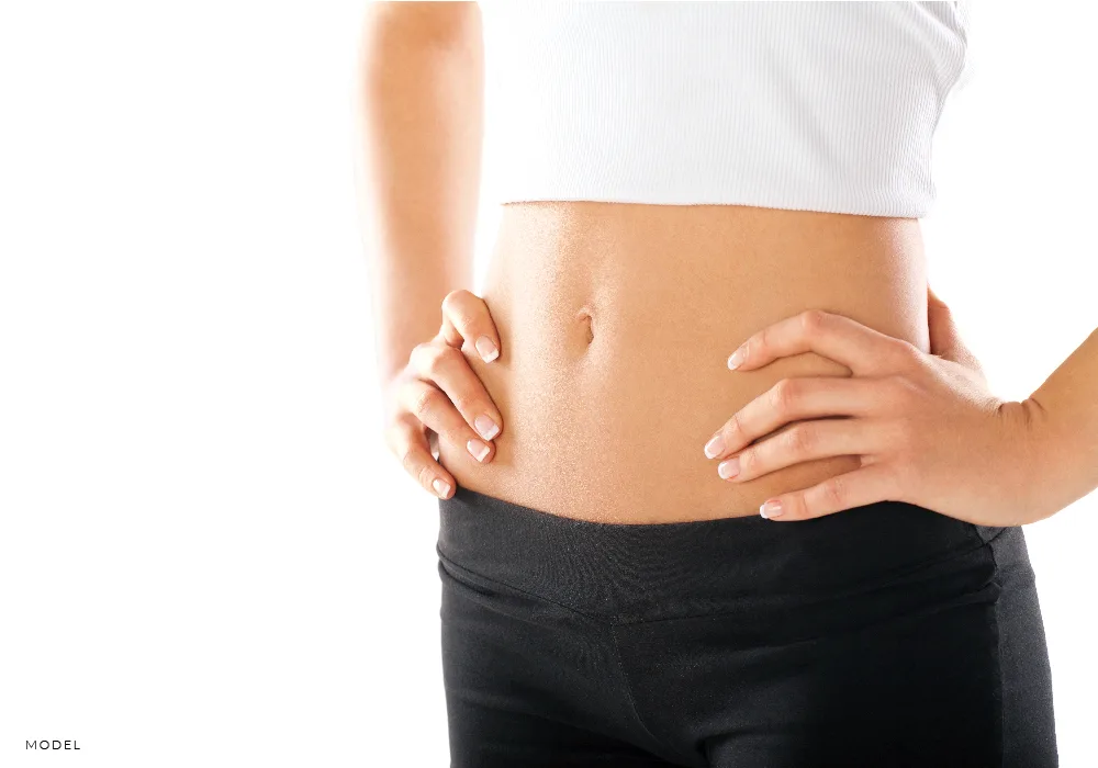 Womans flat tummy with hands on waist