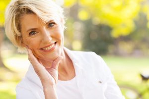 Older Woman in White Shirt Posing Outdoors