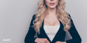 blond female chest wearing a white tank with a black sweater