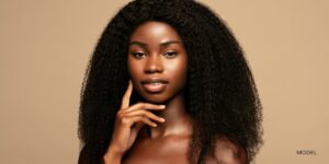 young african american woman with her hand to her face gazing forward