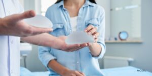 model patient and doctor holding two different breast augmentation implant options