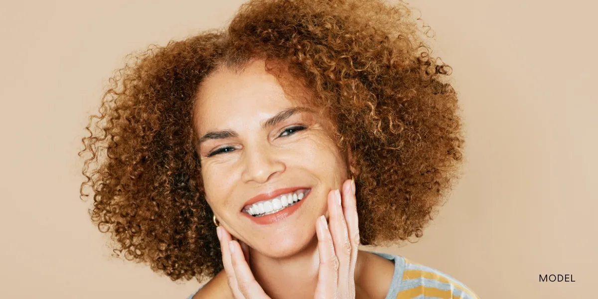 Model touching chin with both hands